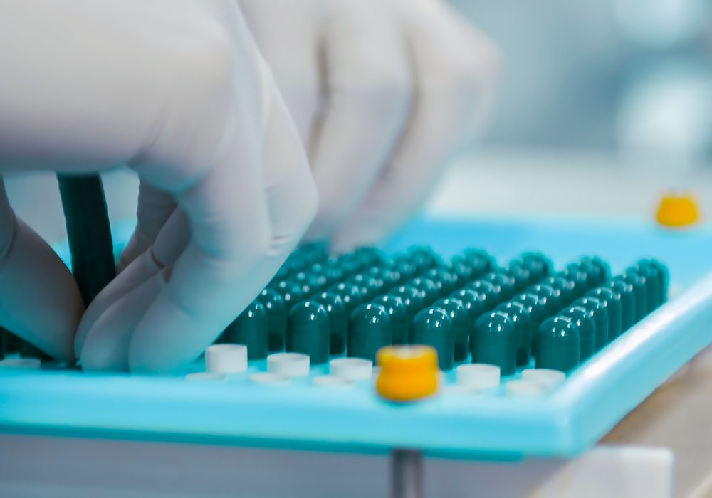 Technician inspecting capsules in a clean supplement lab